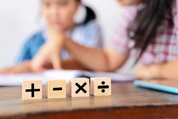 Le professeur enseigne à une fille asiatique Ils apprennent les mathématiques Signes mathématiques addition soustraction multiplication et division