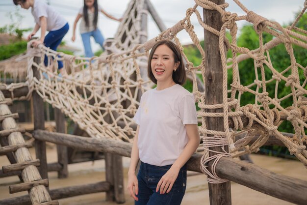 Professeur heureux femme asiatique debout sur fond de terrain de jeu