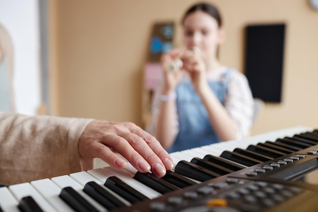 Professeur jouant du piano en classe de musique