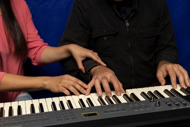 Un professeur latino-américain enseigne et corrige la posture pour jouer du clavier de piano