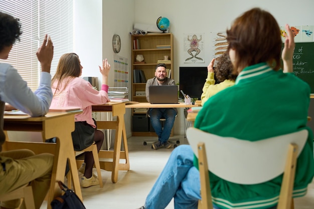 Professeur mature confiant d'anatomie posant des questions aux élèves du secondaire