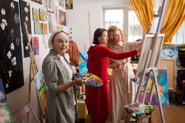 Professeur Mélangeant La Gouache. Beau Professeur D'art âgé Mélangeant La Gouache Debout Près D'étudiants Talentueux