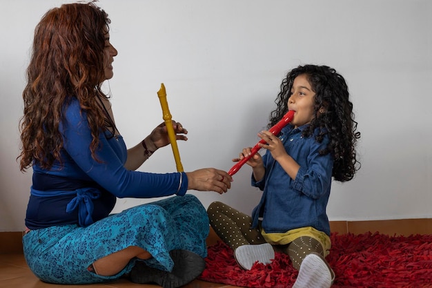 Professeur de musique latino-américaine donnant des cours de flûte à bec à sa fille
