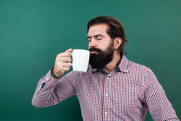 Professeur d'université de type mal rasé brutal au tableau, café du matin.