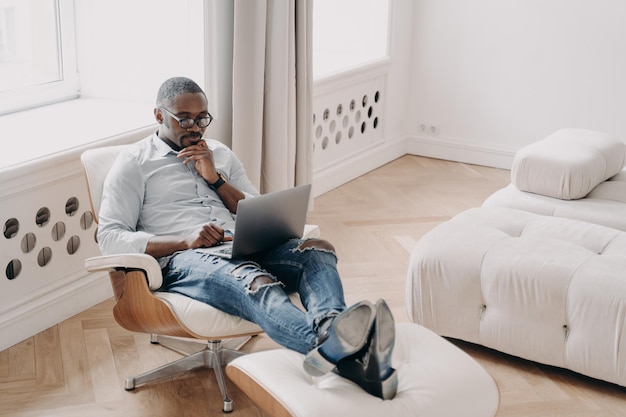 Professionnel Confiant Au Travail Devant Un Ordinateur Portable Homme D'affaires Africain Détendu Dans Une Chaise Confortable