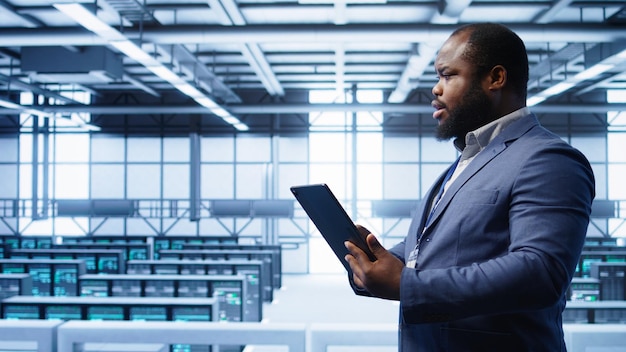 professionnel de l'informatique dans la surveillance des centres de serveurs des serveurs principaux à l'aide d'une tablette