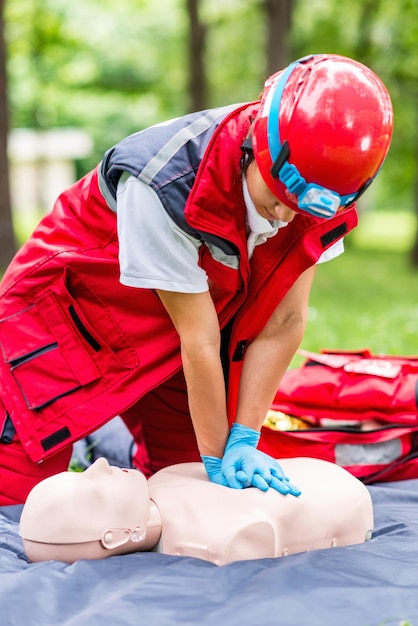 Photo un professionnel de la santé s'entraîne sur un mannequin de rcp dans un parc