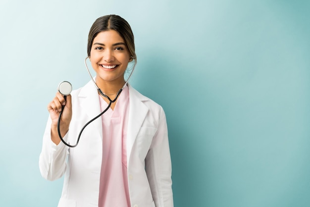 Professionnel de la santé souriant avec stéthoscope sur fond coloré