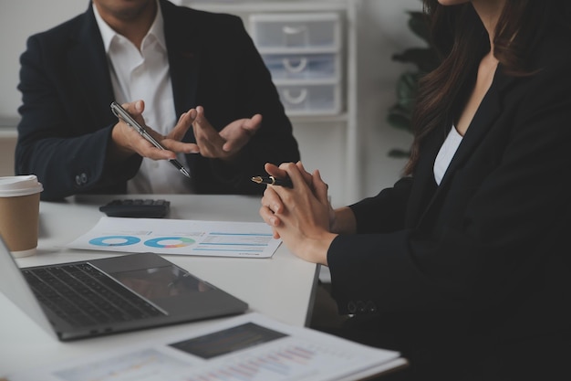 Professionnels d'affaires Groupe de jeunes hommes d'affaires confiants analysant des données à l'aide d'un ordinateur tout en passant du temps au bureau