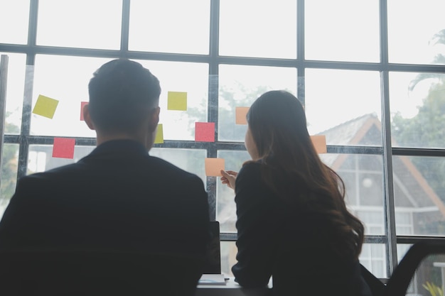 Professionnels d'affaires Groupe de jeunes hommes d'affaires confiants analysant des données à l'aide d'un ordinateur tout en passant du temps au bureau