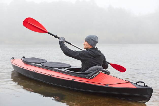 Profil de bel homme bateau à rames et à la recherche de distance, sport extrême de l'eau