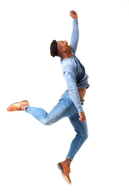 Profil complet du corps d'un jeune homme noir heureux sautant de joie sur un fond blanc isolé
