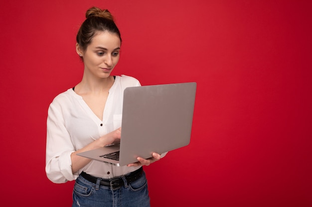 Profil de côté de la belle jeune femme brune tenant un ordinateur netbook