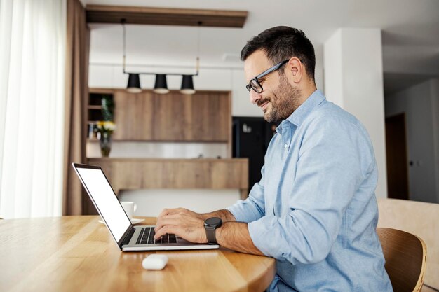 Profil d'un développeur tapant sur un ordinateur portable et travaillant à domicile