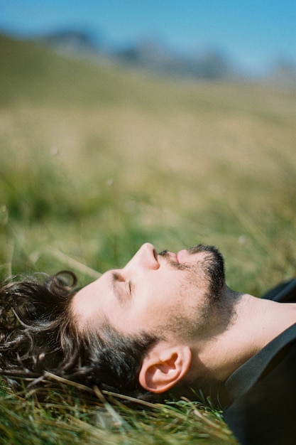 Profil d'un homme allongé sur l'herbe verte