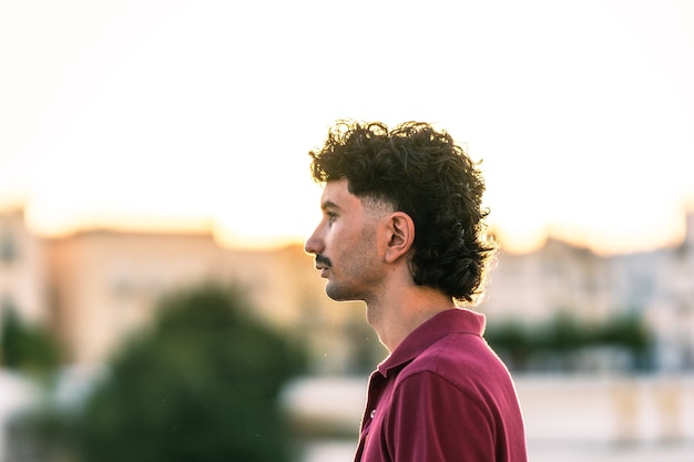 Profil d'un jeune homme au look moderne dans un paysage urbain