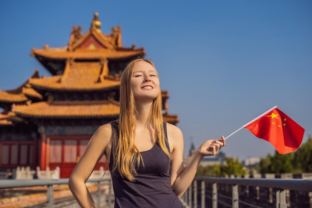 Profitant de vacances en Chine Jeune femme avec le drapeau national chinois dans la Cité Interdite Concept de voyage en Chine Transit sans visa 72 heures 144 heures en Chine