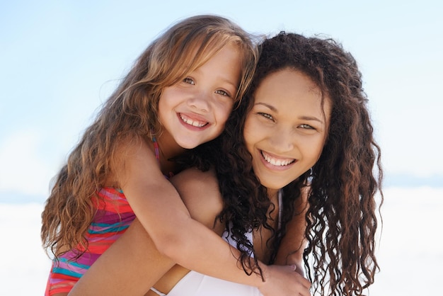 Profiter au maximum de leurs vacances d'été Une jeune mère et sa fille souriant à la plage