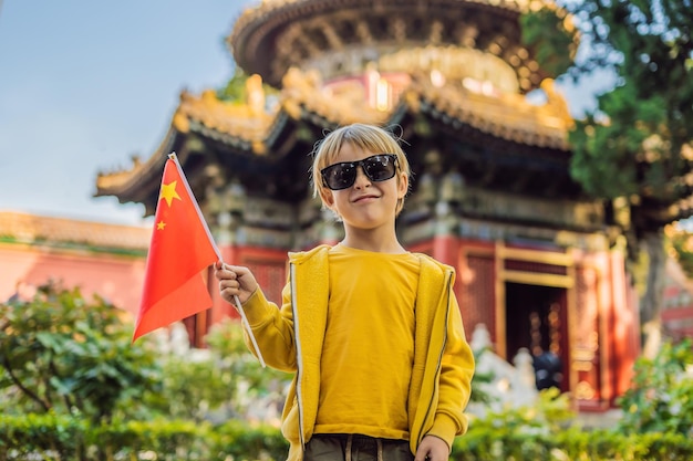 Profiter de vacances en Chine Jeune garçon avec le drapeau national chinois dans la Cité Interdite Voyage en Chine avec le concept d'enfants Transit sans visa 72 heures 144 heures en Chine