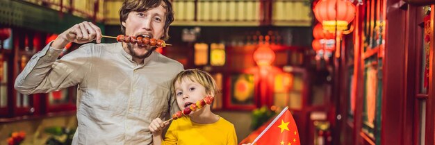 Profiter de vacances en chine touristes heureux papa et fils avec un drapeau chinois et avec des