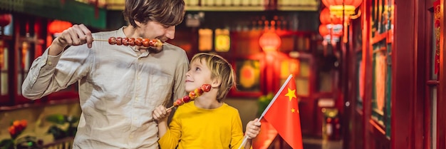 Profiter de vacances en chine touristes heureux papa et fils avec un drapeau chinois et avec des
