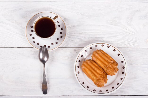 Profiteroles à la crème sur la table avec une tasse de café