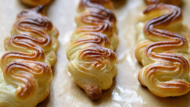 Profiteroles ou éclairs sans crème sur le plat allant au four close up black backgroundxAxA