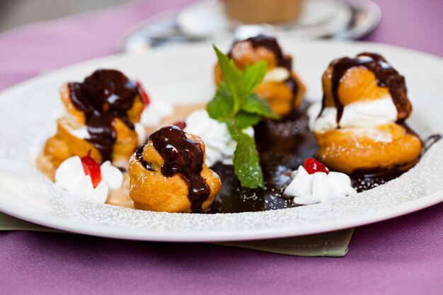 Profiteroles avec glace et chocolat sur assiette