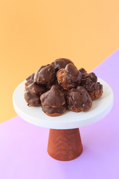 Profiteroles maison au chocolat. Choux à la crème fourrés de crème pâtissière à la vanille sur fond clair. Profiteroles à la crème au chocolat