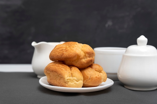 Profiteroles maison sur table sur surface grise. Bouffées, popovers. Éclairs traditionnels français.