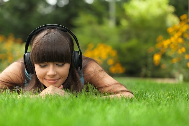 Profitez de la musique, jeune femme au casque dans le parc