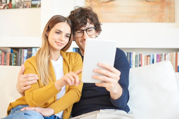 Profitez de la navigation sur Internet ensemble Photo d'un charmant jeune couple se relaxant à la maison et utilisant une tablette numérique