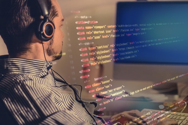Programmateur développant un nouveau code informatique tout en travaillant à la conception de logiciels la nuit au bureau