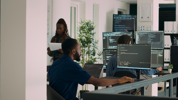 Programmeur de base de données travaillant sur un code de script html pour développer un serveur d'application de programme avec une nouvelle interface d'utilisation. Développeur Web tapant sur le clavier, calculant de grandes données sur la fenêtre du terminal au bureau.