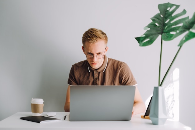 Programmeur développeur mobile écrit le code du programme sur un ordinateur portable au bureau à domicile