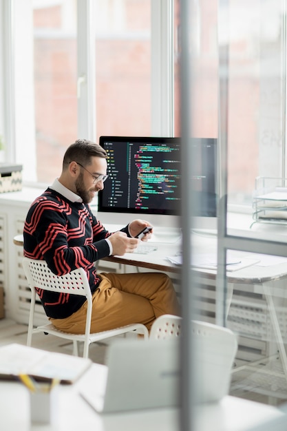 Photo programmeur souriant travaillant au bureau