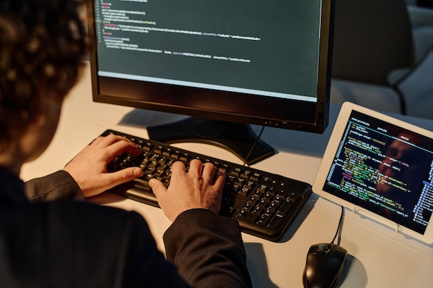 Programmeur tapant des codes sur ordinateur pour un nouveau logiciel