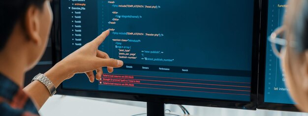 Une programmeuse explique en pointant le code affiché sur un ordinateur