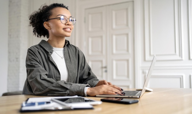 Une programmeuse à lunettes travaille sur un projet en ligne