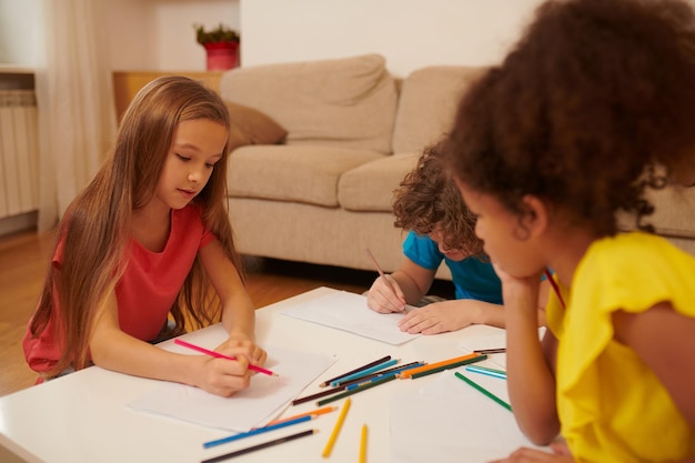 Projet. Groupe d'enfants dessinant quelque chose et semblant impliqués