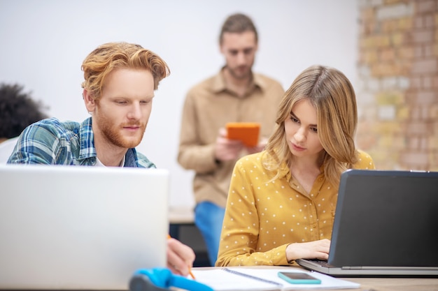 Projet. Jeunes professionnels travaillant ensemble au bureau et discutant du projet