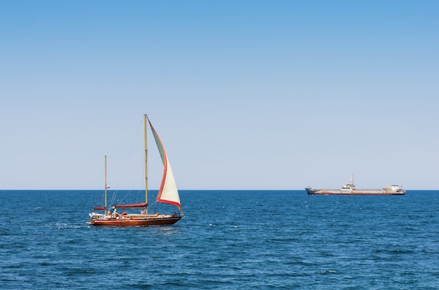 Promenade en bateau sur le yacht en pleine mer. Yacht de plaisance avec touristes et cargo en mer Noire