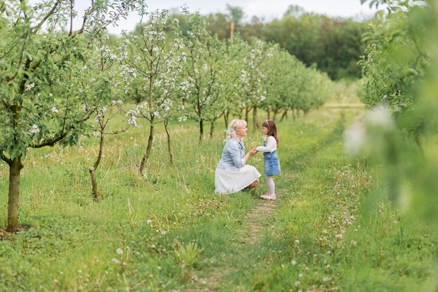 Promenade dans le jardin printanier d'une mère avec une petite fille