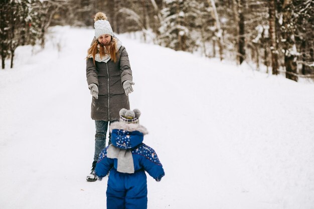 Promenade en famille dans la forêt d'hiver Maman et bébé en hiver Maternité Attraper des flocons de neige