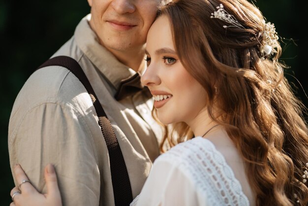 Photo promenade de mariage des mariés dans un parc de conifères en été