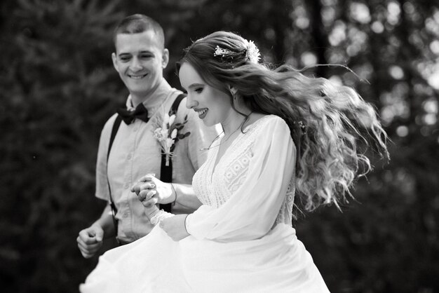 Photo promenade de mariage des mariés dans un parc de conifères en été