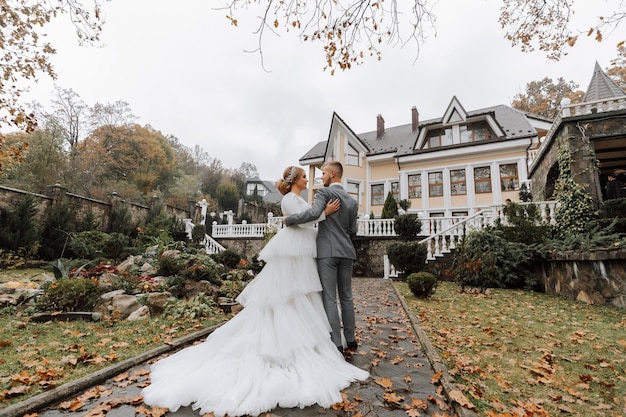 Photo une promenade de la mariée et du marié dans un parc avec une belle architecture balustrades blanches mariée avec un long train