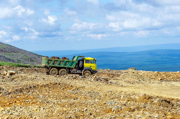 Des promenades en camion à benne chargée sur la route de montagne en construction