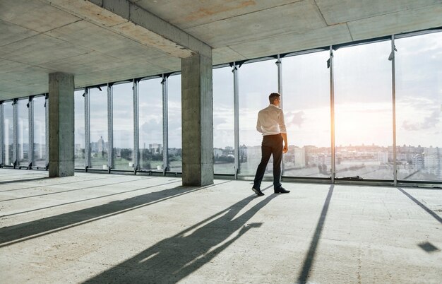 Promenades et discussions Jeune homme en tenue de soirée travaille à l'intérieur sur la construction