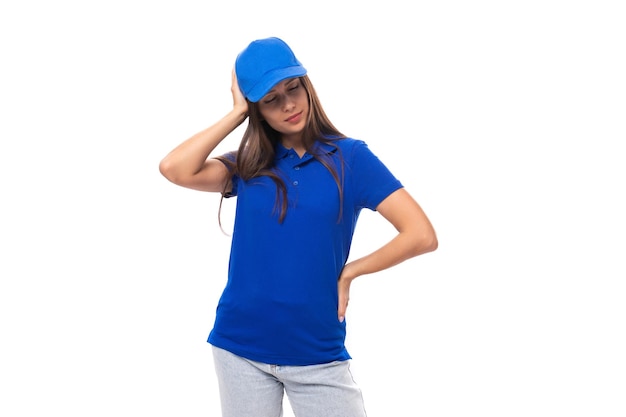 Photo promoteur de jeune femme brune soignée dans un t-shirt bleu et une casquette sur fond blanc avec copie